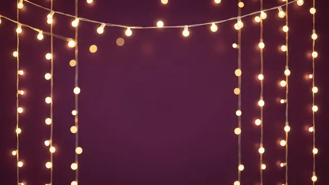 Warm golden fairy light bokeh frames an empty deep plum colored center space