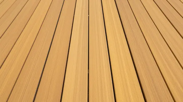 Full frame top view of parallel golden teak deck planks separated by thin dark seams