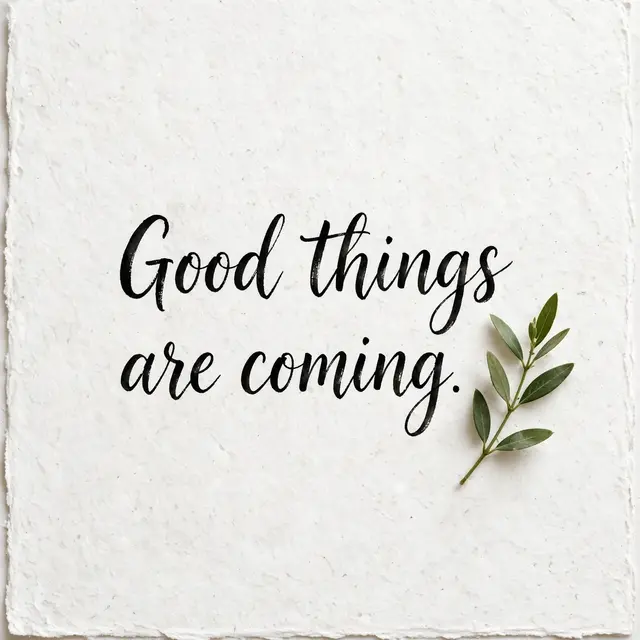 "Good things are coming." black brush lettering on textured white paper with a small green leaf sprig