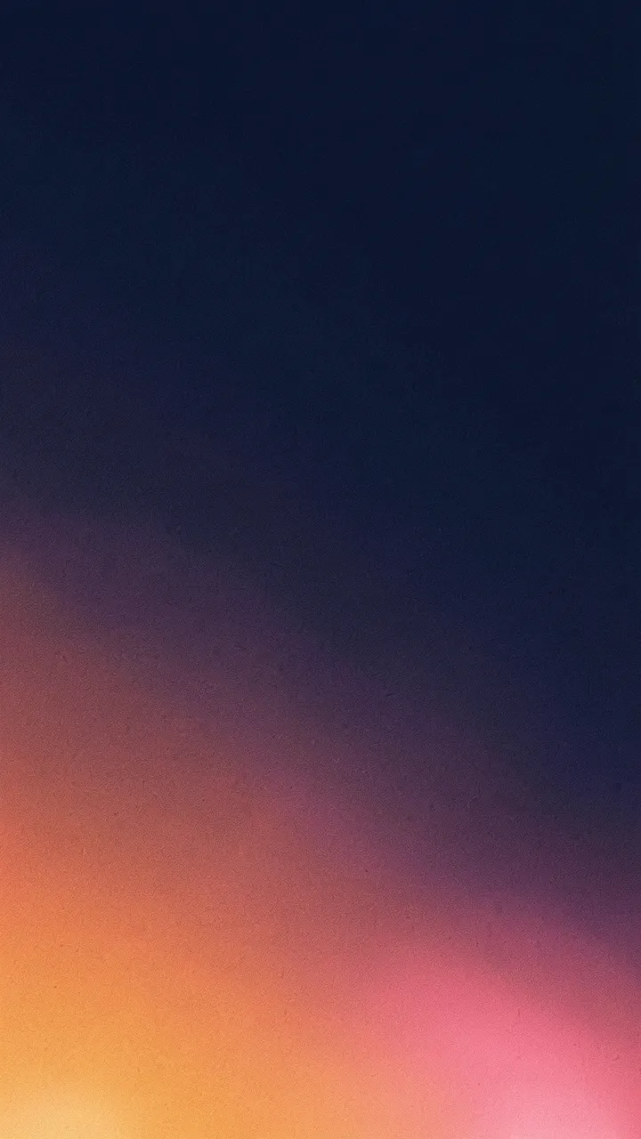 Vertical grainy gradient wallpaper with warm tangerine and pink light blooming from the lower corner into deep navy