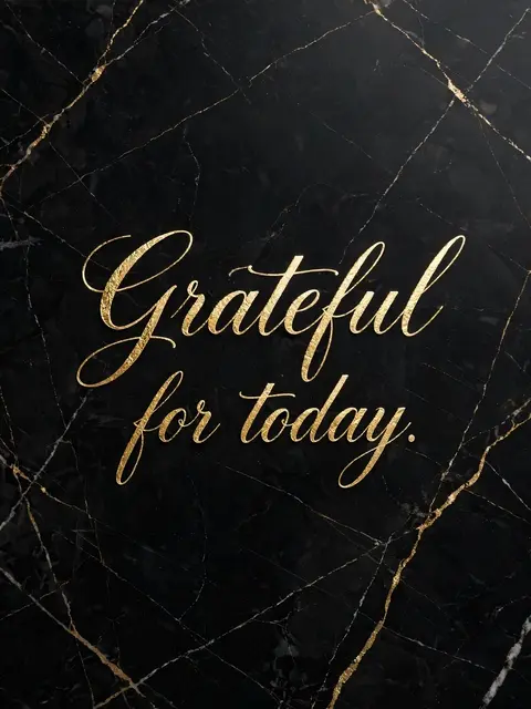 Gold foil script reading "Grateful for today." displayed on polished black marble with gold veining