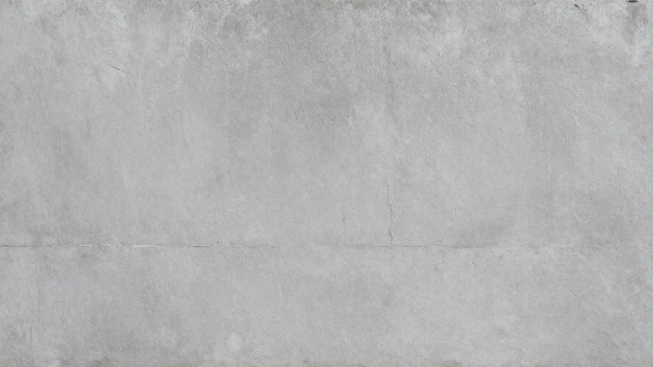 Full frame close-up of a matte, slightly weathered gray concrete wall surface