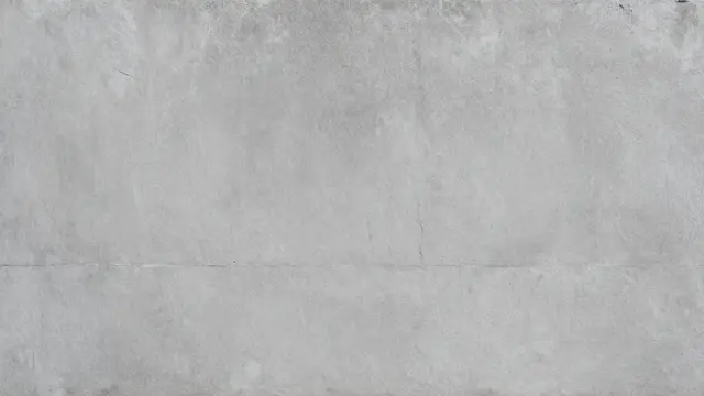 Full frame close-up of a matte, slightly weathered gray concrete wall surface