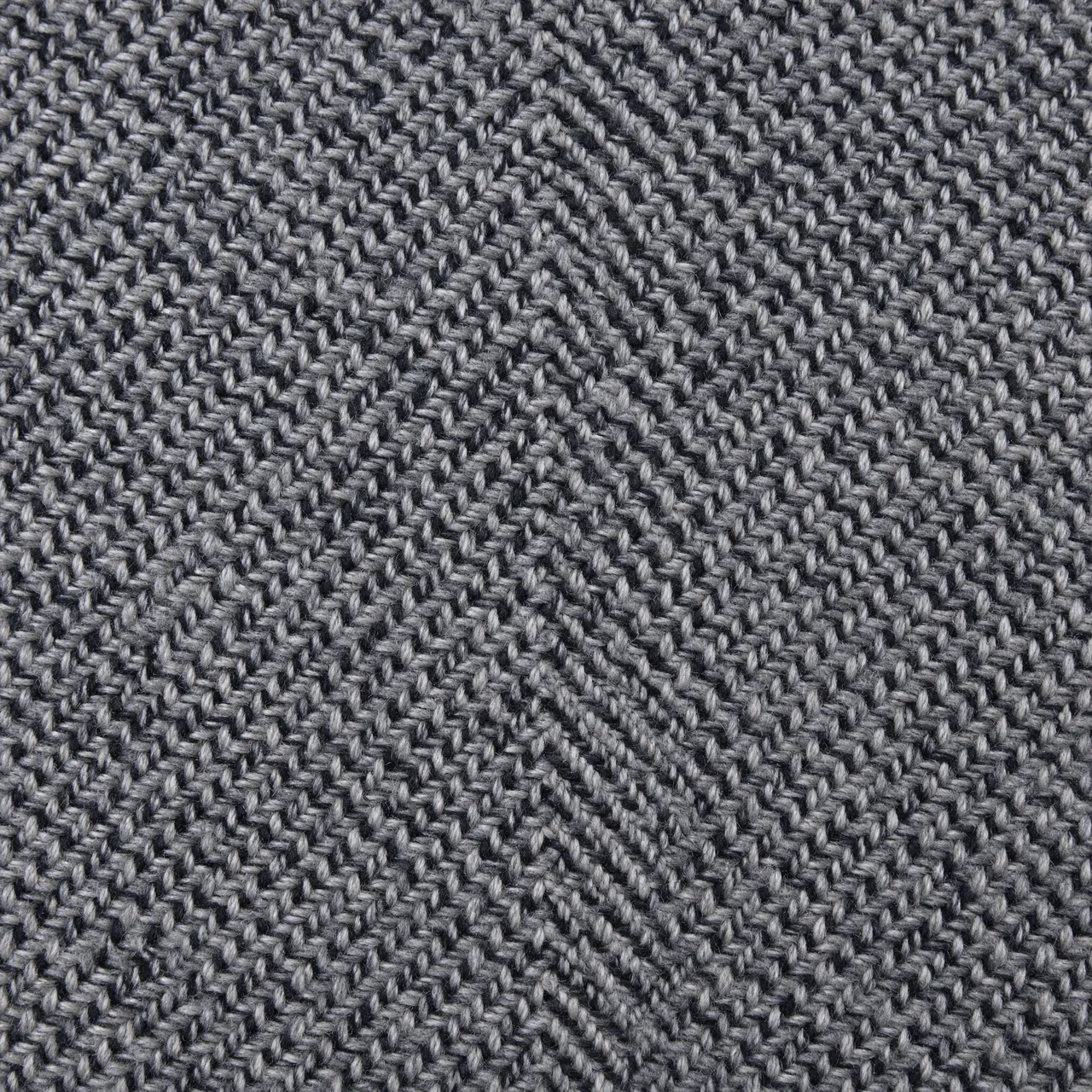 Full frame close-up of gray and black woven herringbone tweed fabric with even lighting