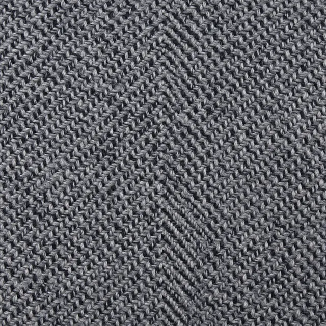 Full frame close-up of gray and black woven herringbone tweed fabric with even lighting