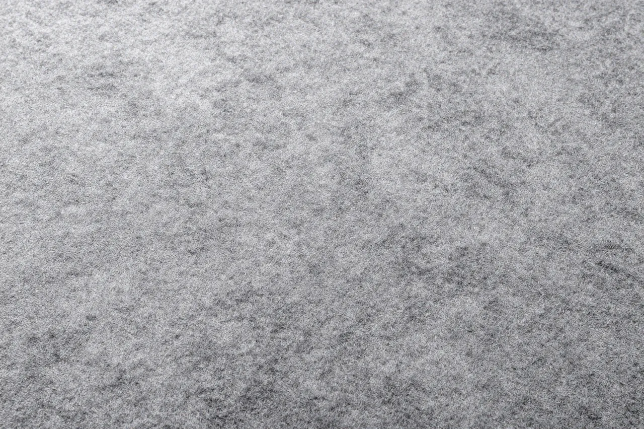 Full frame top view of soft gray cut pile carpet with natural subtle shading across its surface