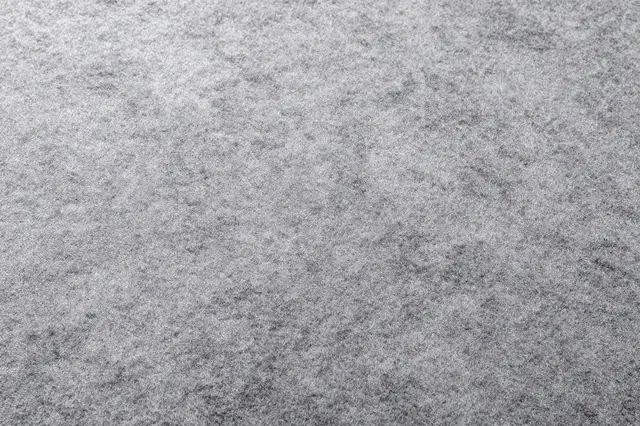 Full frame top view of soft gray cut pile carpet with natural subtle shading across its surface