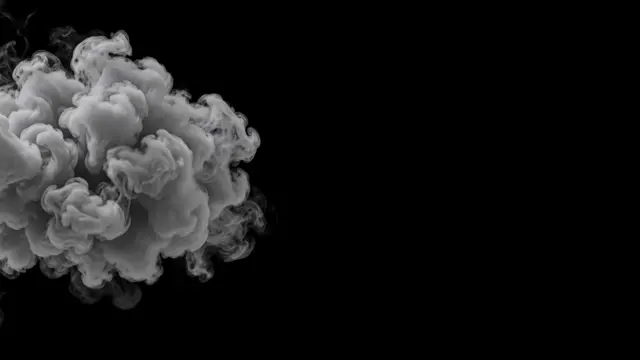 Thick billowing gray smoke drifts in from the left against a solid pure black background