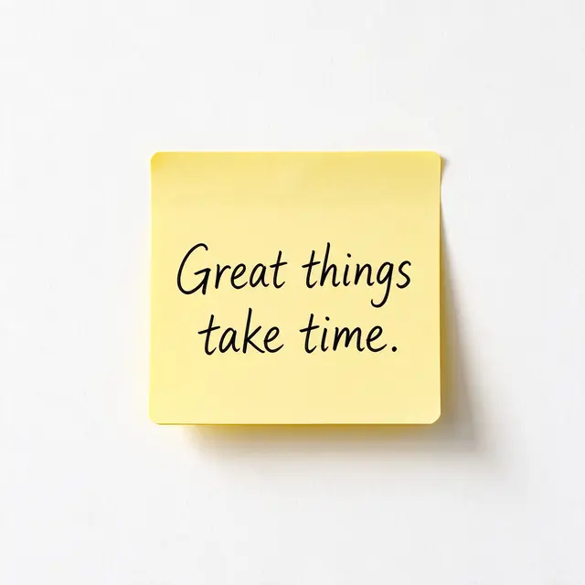 A yellow sticky note on a white wall displays the handwritten quote "Great things take time."