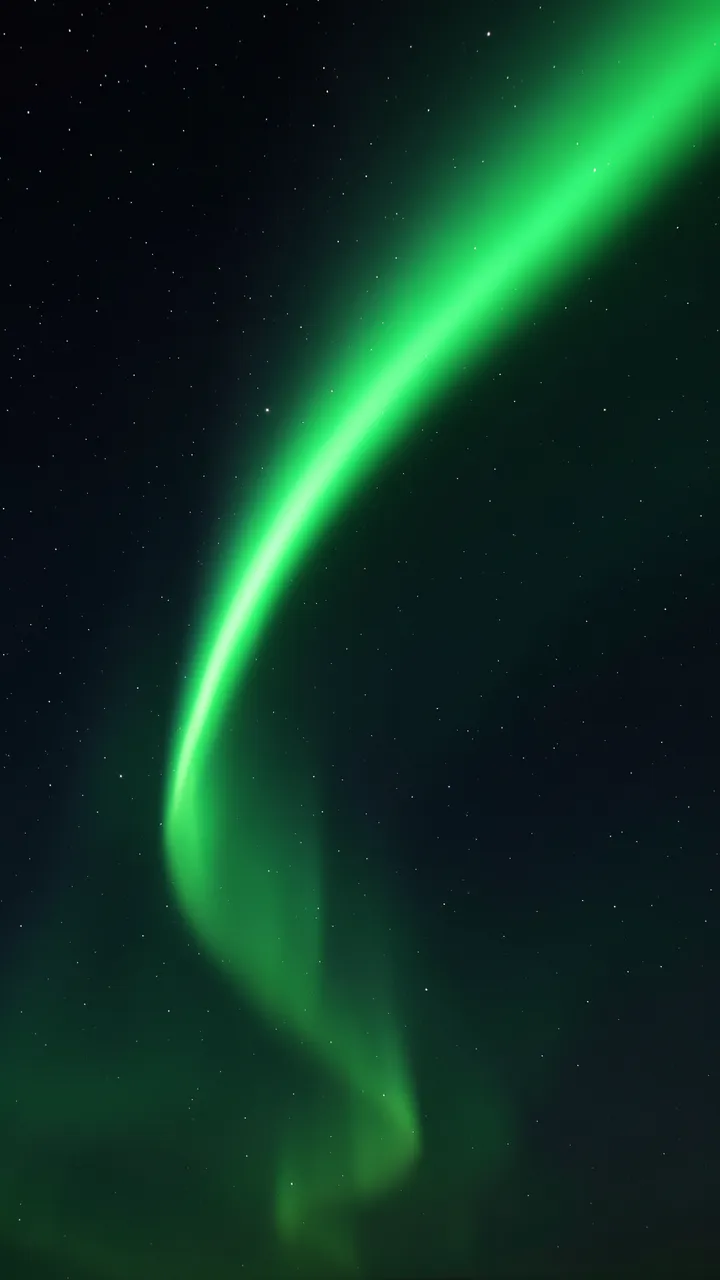 Luminous curved green aurora arc stretches across a dark star-filled night sky
