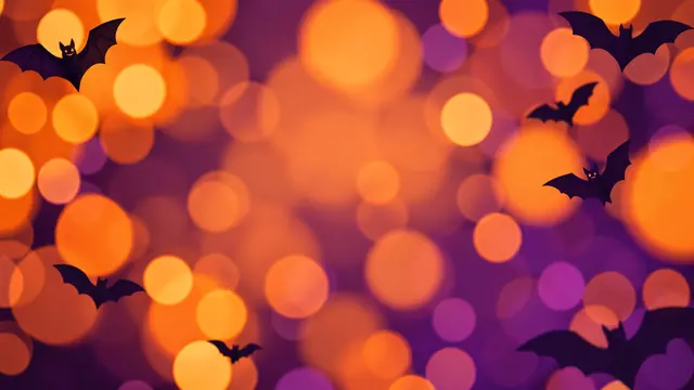 Black bat silhouettes float over soft orange and purple circular bokeh lights with central empty copy space