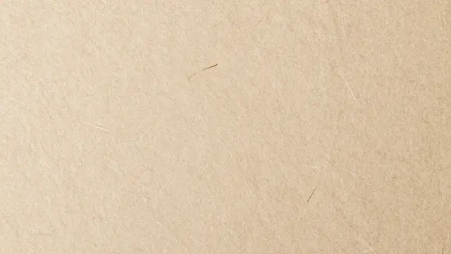 Full frame close-up of natural light brown handmade paper with visible embedded fiber strands