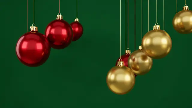 Glossy red and gold Christmas baubles hang at varying heights against a solid deep green background