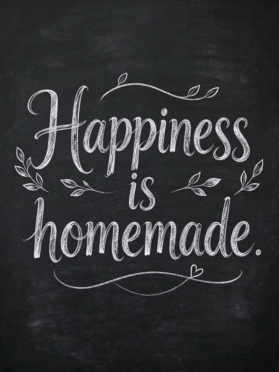 White chalk hand lettering reading "Happiness is homemade." with decorative flourishes on a dark chalkboard background