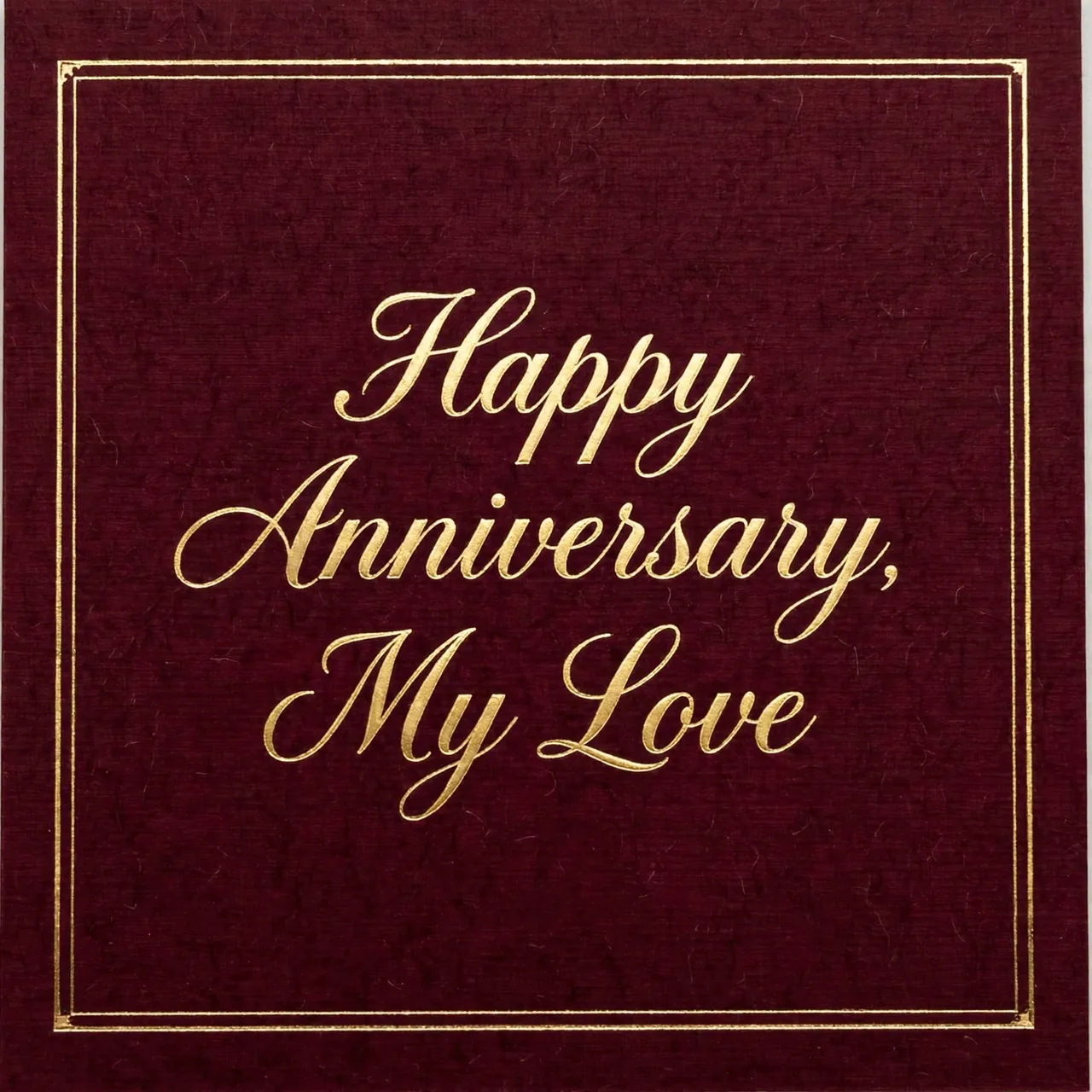 Gold foil script reading "Happy Anniversary, My Love" centered on a deep burgundy card with a thin gold frame