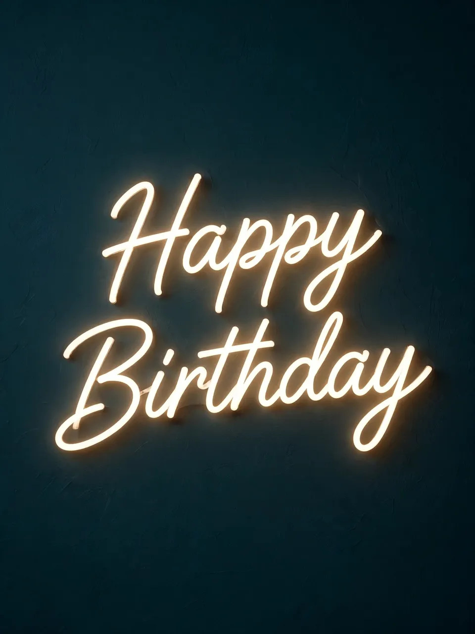 Warm white neon script reading "Happy Birthday" glows against a dark teal textured wall