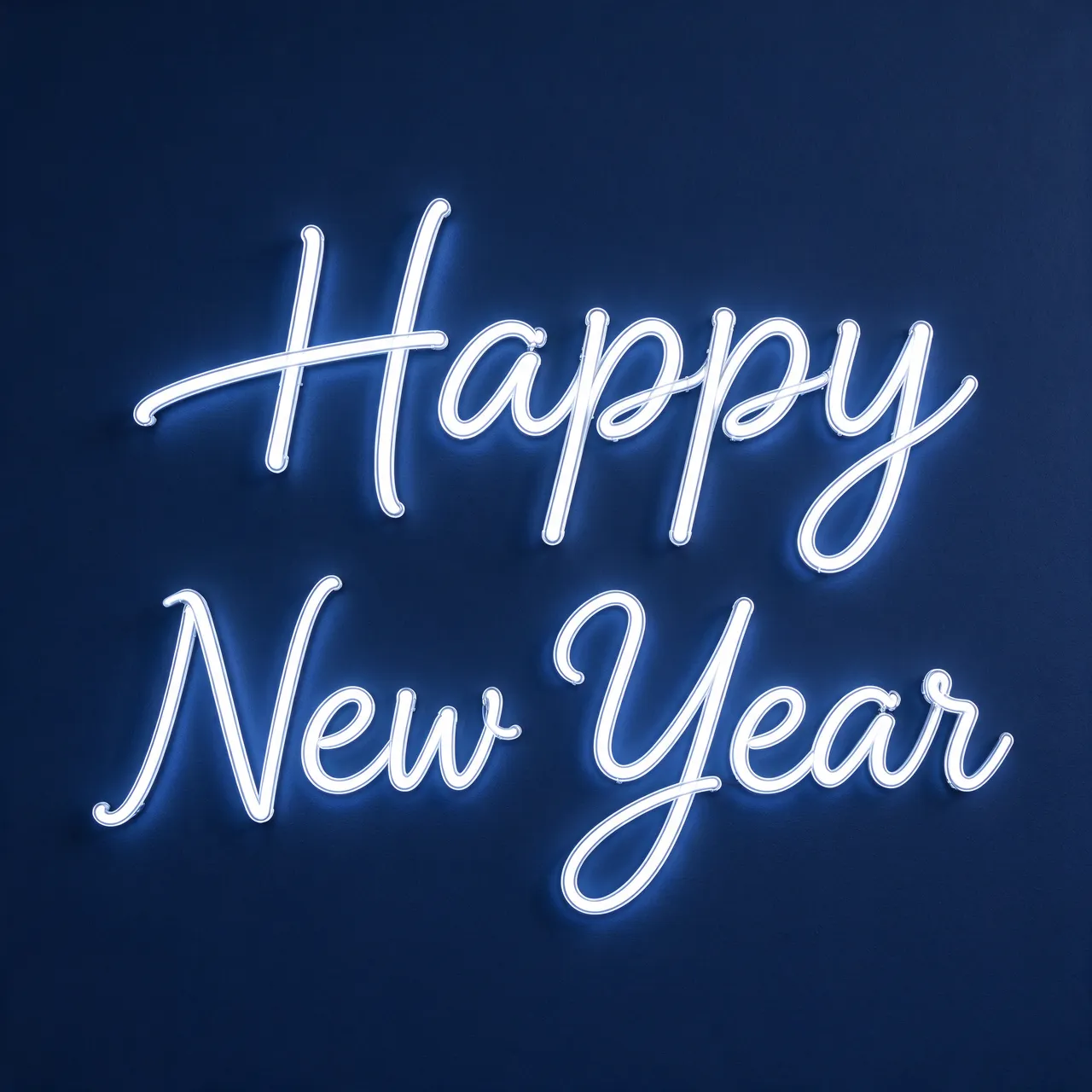 Glowing white neon script sign reading "Happy New Year" mounted on a dark navy wall
