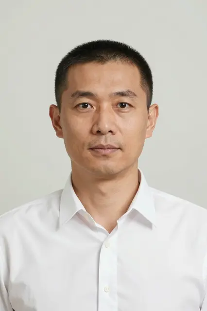 Studio portrait of a forties East Asian man in a white button-down shirt against a pale backdrop