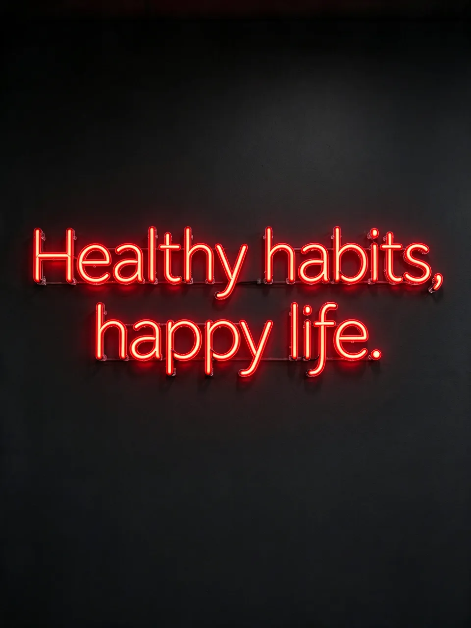 Glowing red neon sign reading "Healthy habits, happy life." mounted on a dark plain wall