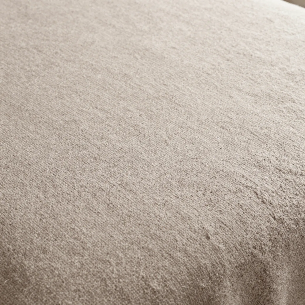 Full frame close-up of a soft heathered taupe woven wool blanket surface with fuzzy nap