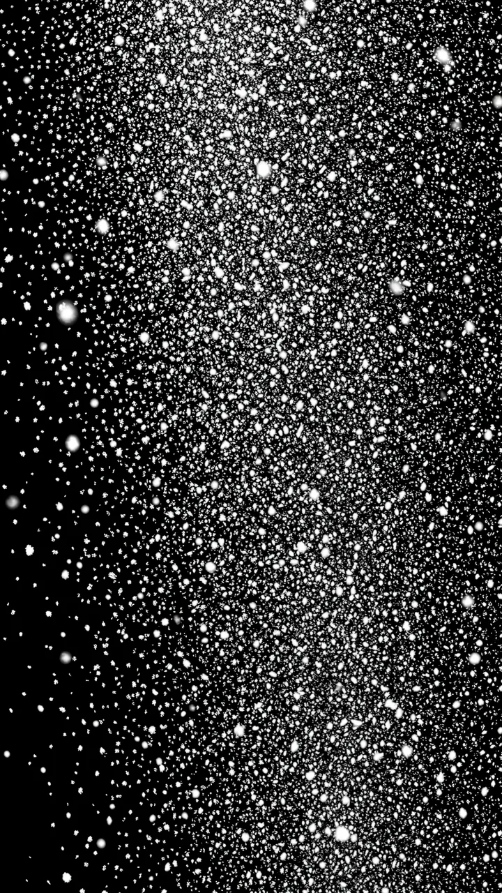Dense falling small white snow flakes scattered across a solid pure black background