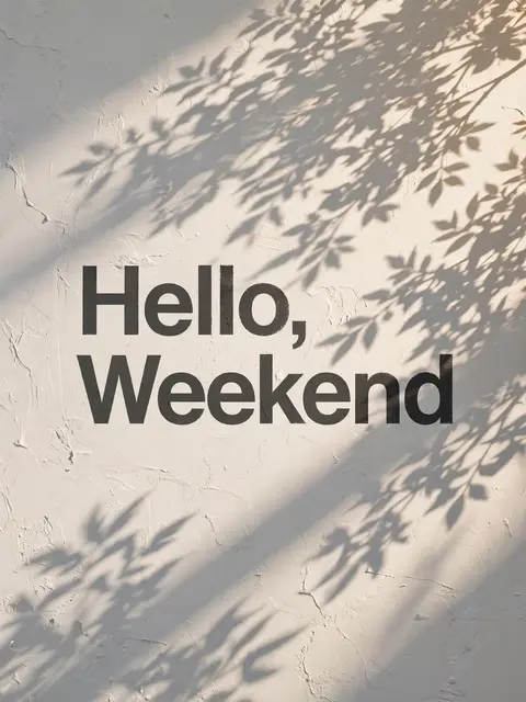 "Hello, Weekend" text printed on a sunlit textured white wall with dappled plant leaf shadows