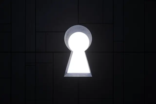 A bright glowing keyhole cutout sits centered in a dark tiled paneled wall