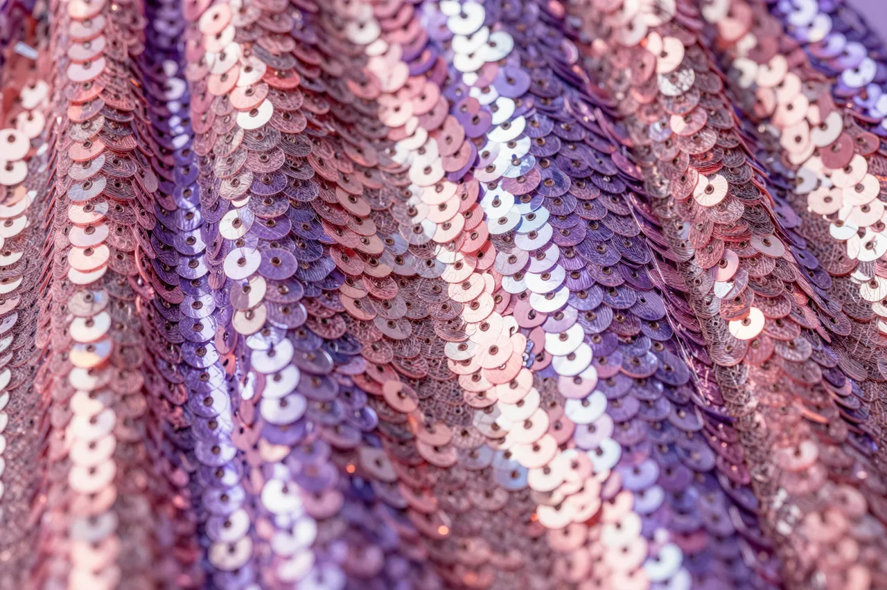 Close-up full frame of shimmering pink and purple iridescent sequin fabric