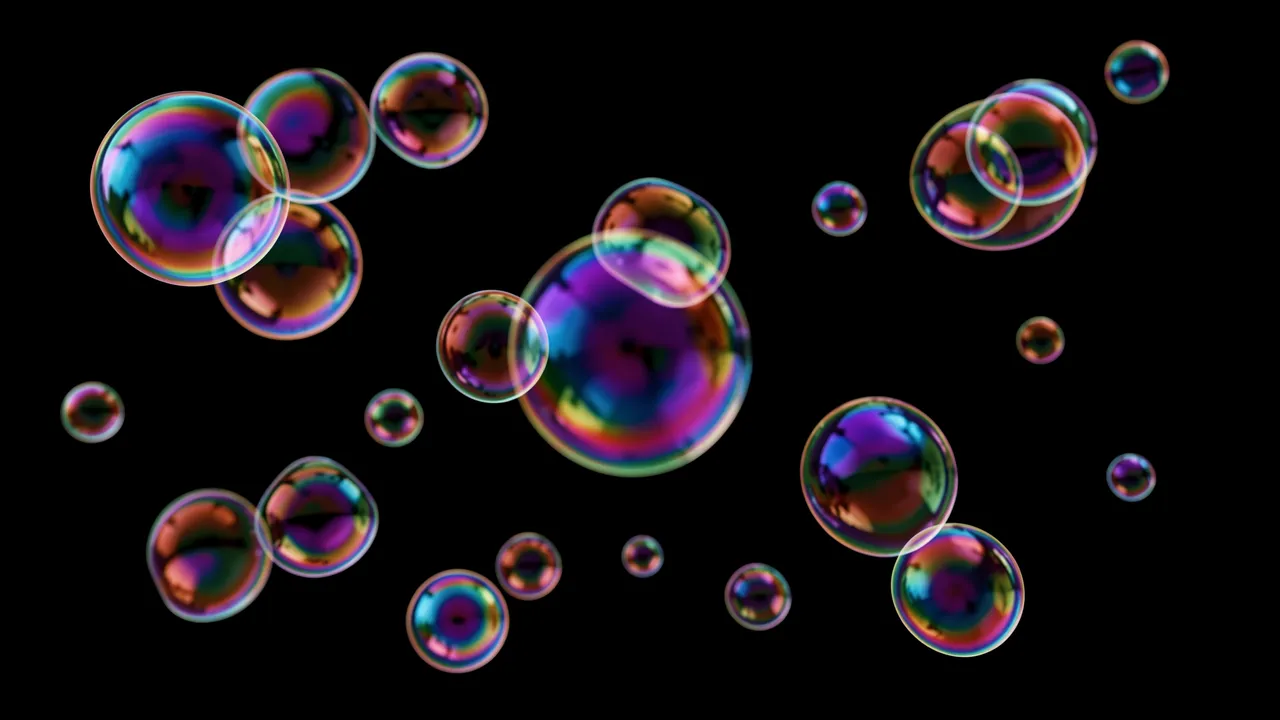 Floating iridescent soap bubbles of varying sizes drift across a solid pure black background.