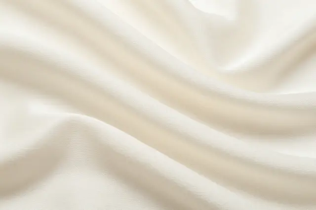 Soft draped ivory raw silk fabric with gentle natural folds and subtle surface texture