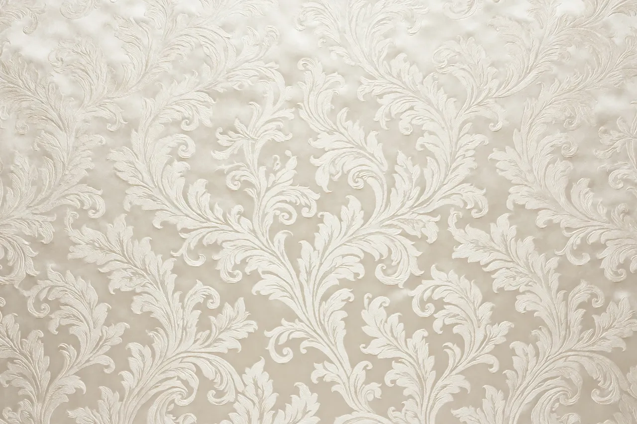 Full frame close-up of ivory tone-on-tone silk damask fabric with scrolling leaf patterns and soft satin sheen