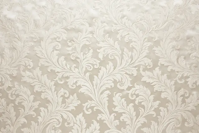 Full frame close-up of ivory tone-on-tone silk damask fabric with scrolling leaf patterns and soft satin sheen