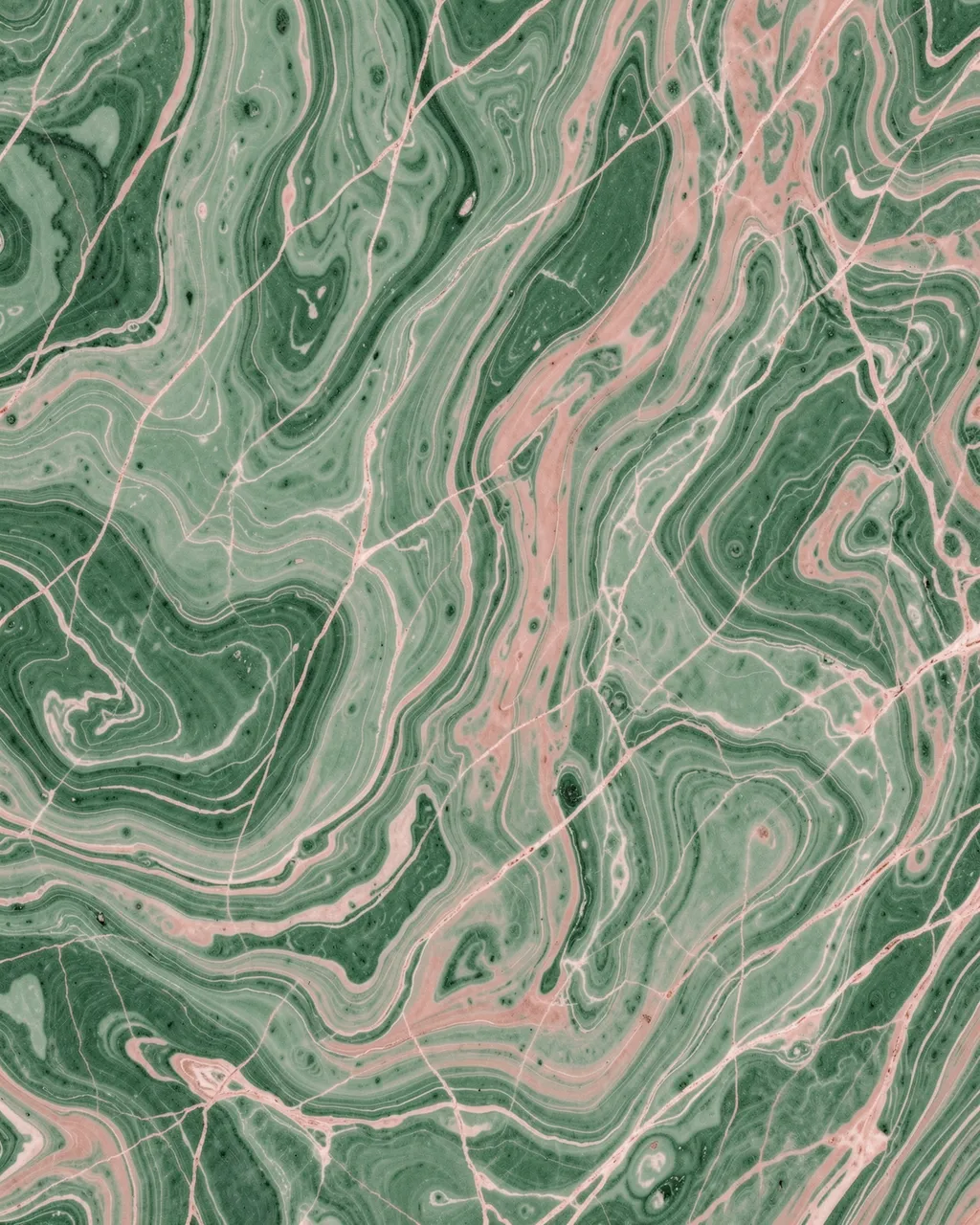 Full frame abstract marbled pattern of jade green and soft blush with fine intersecting veins