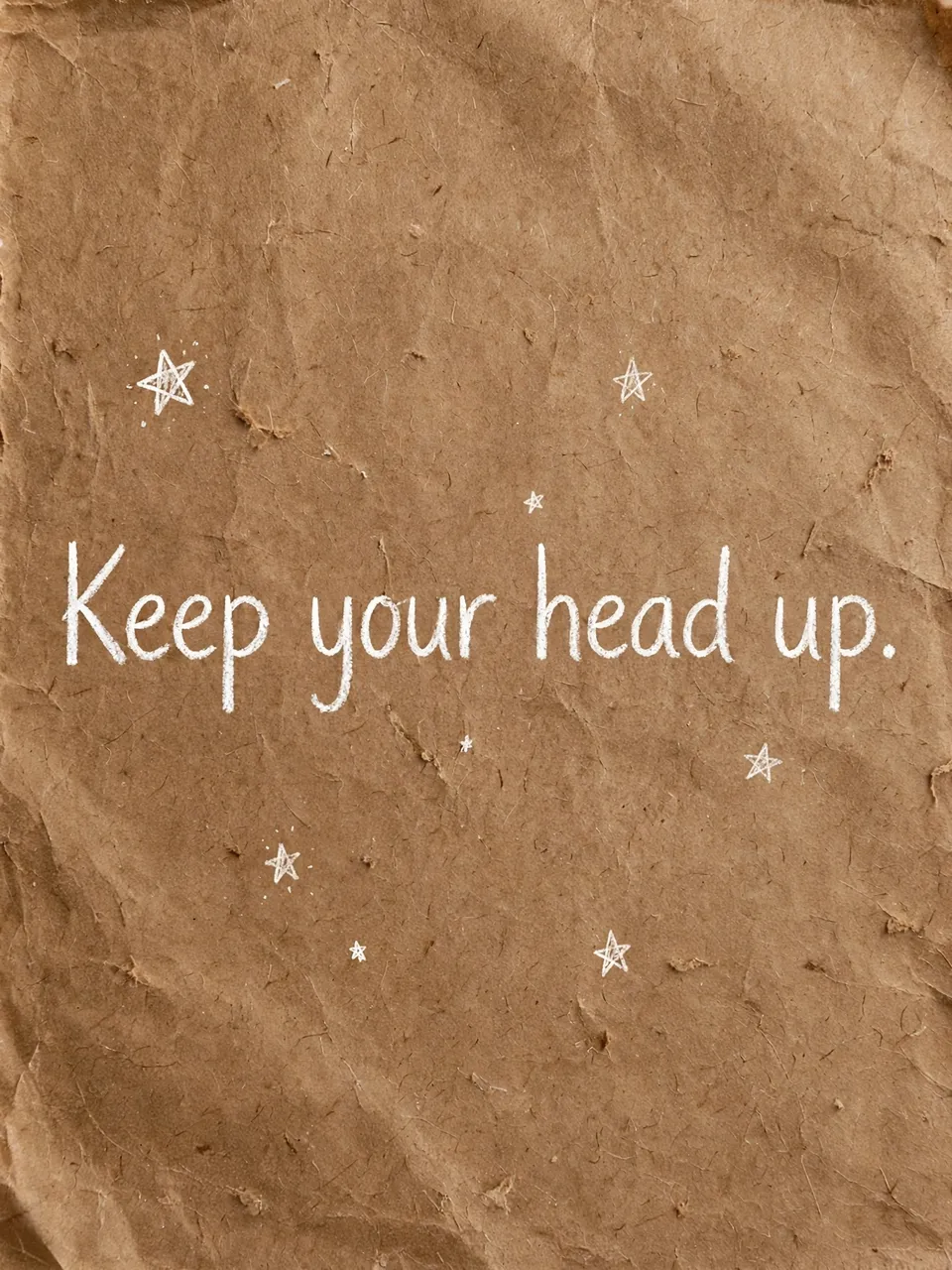 White hand-drawn text "Keep your head up." with small doodled stars on crumpled brown kraft paper