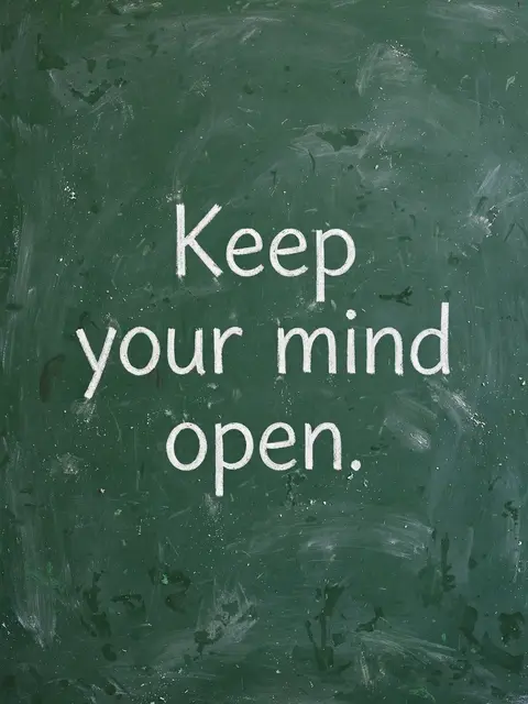 White chalk lettering reading "Keep your mind open." centered on a worn green chalkboard
