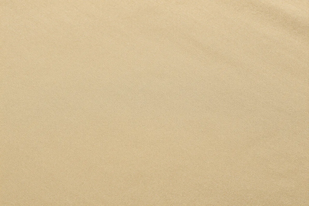 Full frame close-up of smooth khaki cotton twill fabric with fine diagonal weave under even flat lighting