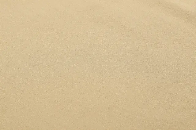 Full frame close-up of smooth khaki cotton twill fabric with fine diagonal weave under even flat lighting