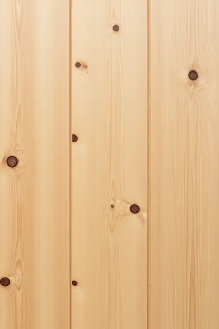 Full frame close-up of light yellow pine wood planks with dark round knots and even lighting