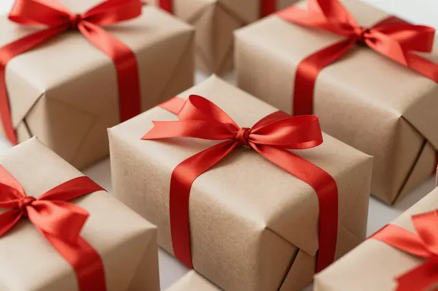 Neatly arranged wrapped gift boxes in brown kraft paper tied with bright red satin ribbons