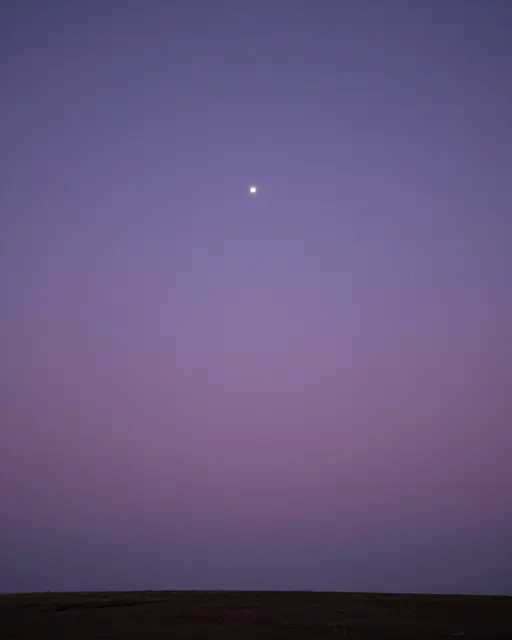 A smooth gradient lavender twilight sky holds a single bright star above a dark flat horizon