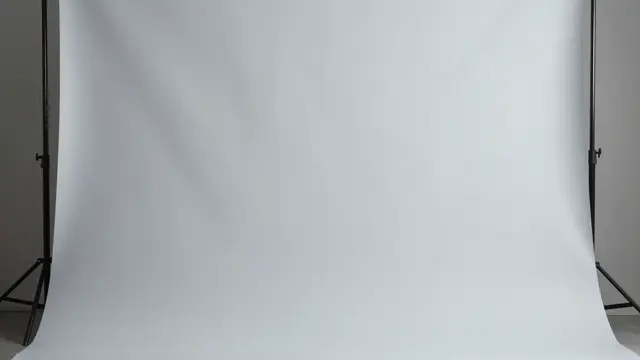 Smooth light gray studio backdrop mounted on black metal support stands with soft even lighting falloff