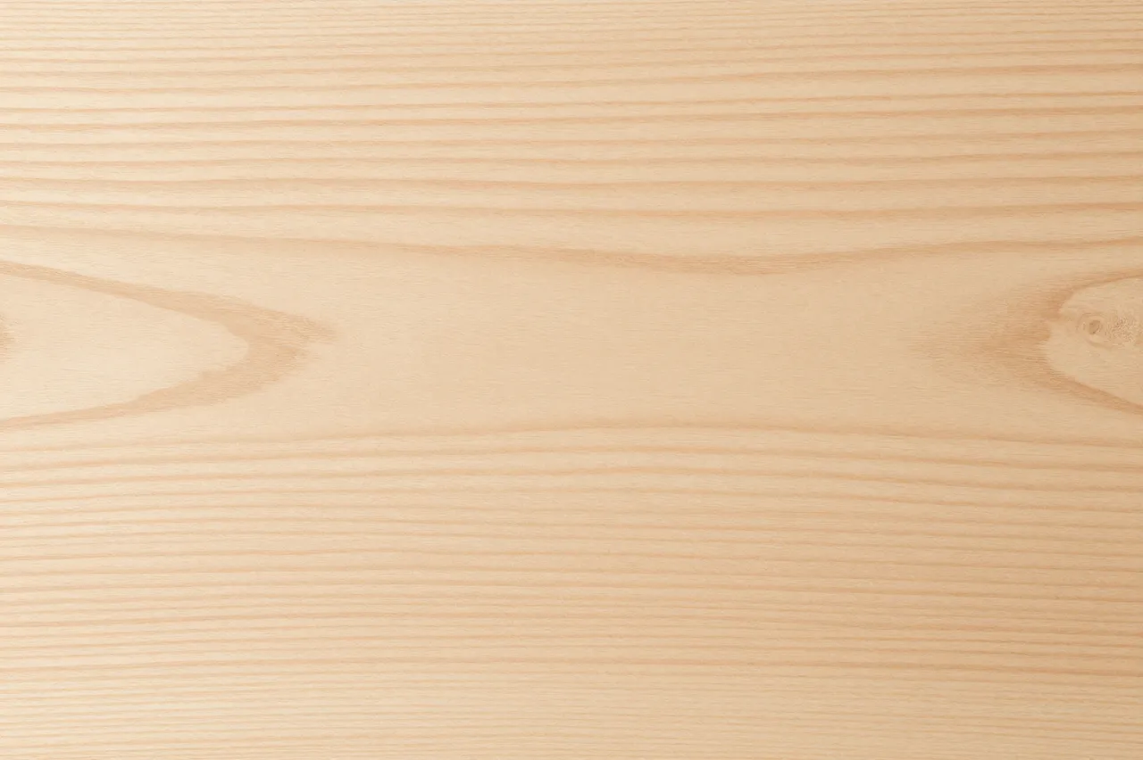 Full frame close-up of smooth light maple wood with fine horizontal grain and subtle knots