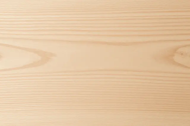 Full frame close-up of smooth light maple wood with fine horizontal grain and subtle knots
