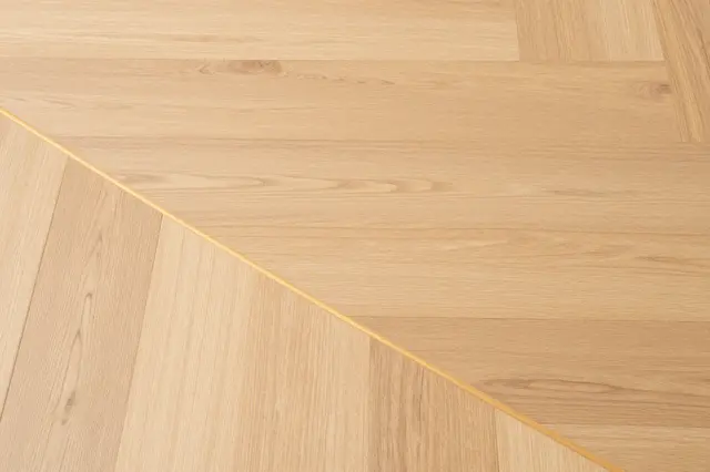 Top view full frame of a natural light oak wood floor with staggered plank layout and even lighting