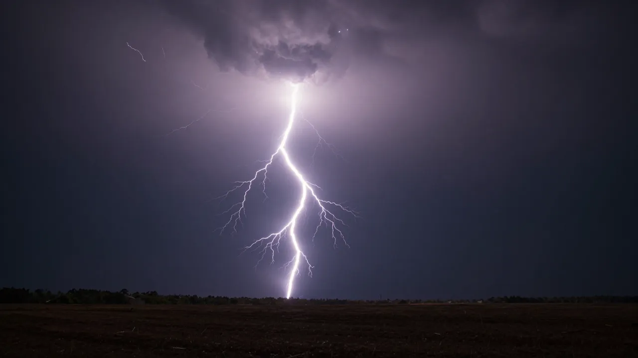 Bright jagged lightning bolt illuminates dark storm clouds above a flat night landscape