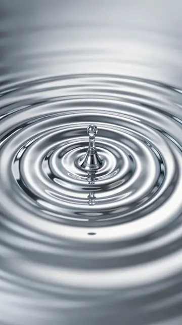 Mirror-bright silver chrome ripples spread outward from a central droplet impact point