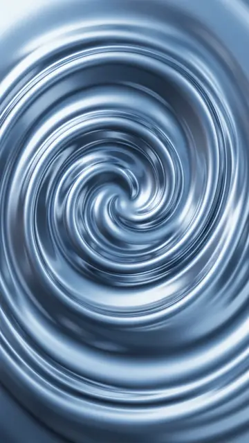 Overhead view of a smooth silver liquid chrome spiral lit with soft cool blue light