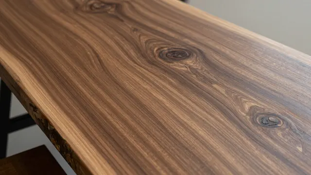 Close-up top view of a polished live-edge acacia slab with contrasting dark and light grain patterns