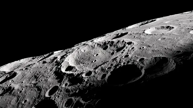 Rugged cratered lunar surface lit by sharp side light along the day-night terminator against black space