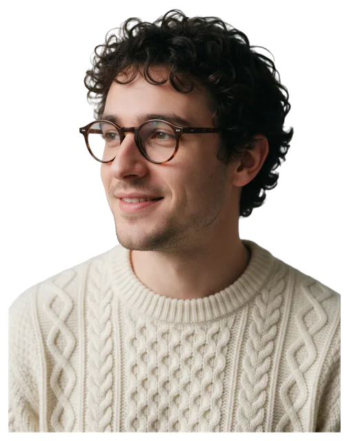 Bust portrait of a young man with curly dark hair, tortoiseshell glasses, and a soft slight smile